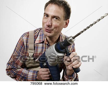 A man holding a large drill View Large Photo Image Stock Photo - A man holding a large drill. Fotosearch