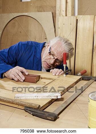 Stock Photo - A man sanding wood. Fotosearch