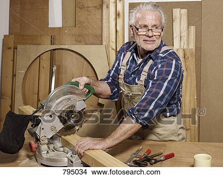 A man sawing wood in a workshop View Large Photo Image Picture - A man sawing wood in a workshop. Fotosearch
