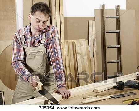 A man sawing wood View Large Photo Image Picture - A man sawing wood. Fotosearch