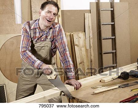 A man sawing wood View Large Photo Image Stock Photo - A man sawing wood. Fotosearch