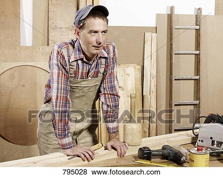 A man standing in a wood workshop View Large Photo Image Stock Photo - A man standing in a wood workshop. Fotosearch