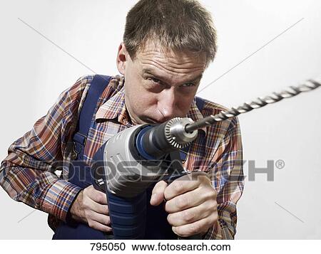 A man using a large drill View Large Photo Image Stock Image - A man using a large drill. Fotosearch