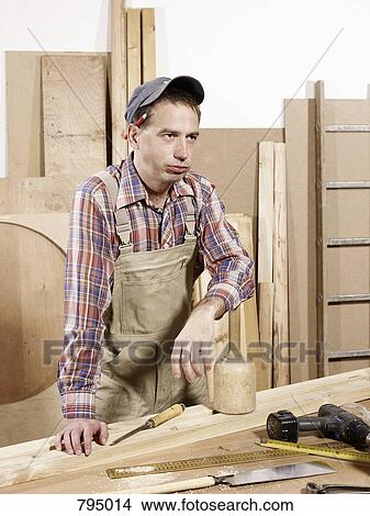 A tired man standing in a wood workshop View Large Photo Image Picture - A tired man standing in a wood workshop. Fotosearch