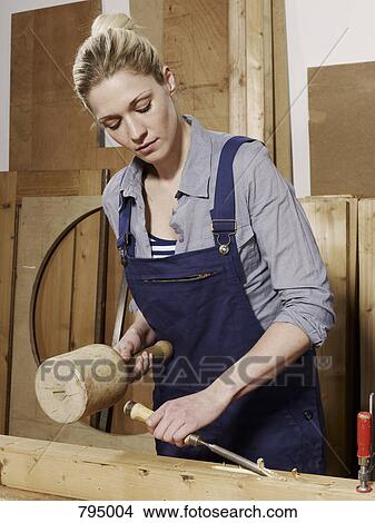 A woman chiseling wood View Large Photo Image Picture - A woman chiseling wood. Fotosearch
