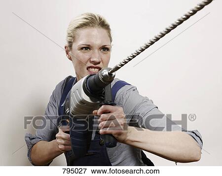 A woman holding a drill View Large Photo Image Stock Photo - A woman holding a drill. Fotosearch