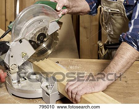 Stock Image - Detail of a man cutting wood. Fotosearch