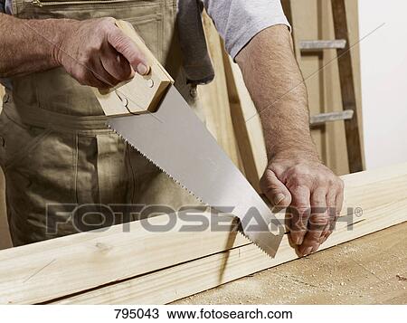 Stock Image - Detail of a man sawing wood. Fotosearch