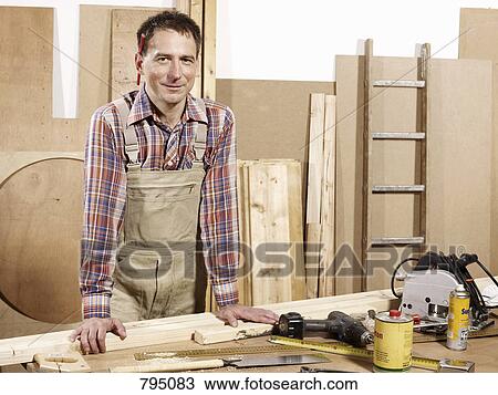 Portrait of a man standing in a wood workshop View Large Photo Image Stock Image - Portrait of a man standing in a wood workshop. Fotosearch