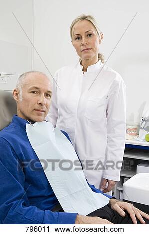 A dental assistant and a patient in a dental examination room View Large Photo Image Stock Image - A dental assistant and a patient in a dental examination room. Fotosearch