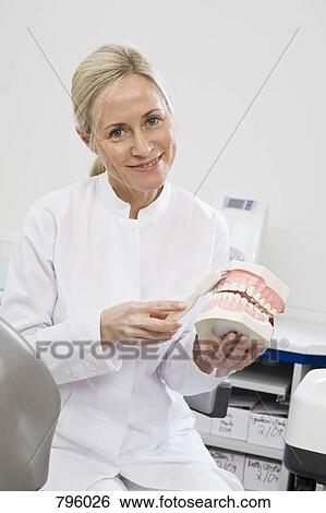 Stock Photograph - A dental assistant demonstrating how to brush . Fotosearch