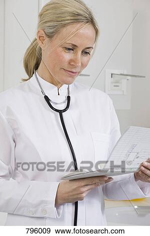 A dental assistant looking at a chart View Large Photo Image Stock Photo - A dental assistant looking at a chart. Fotosearch