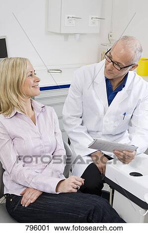 A dentist and a patient in a dental examination room View Large Photo Image Stock Image - A dentist and a patient in a dental examination room. Fotosearch