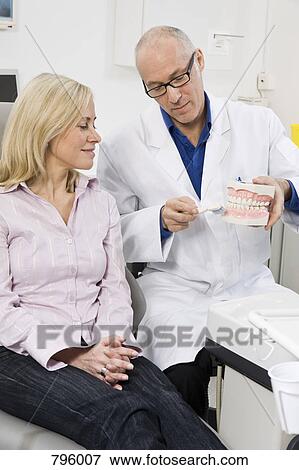 A dentist demonstrating to a patient View Large Photo Image Stock Photo - A dentist demonstrating to a patient. Fotosearch