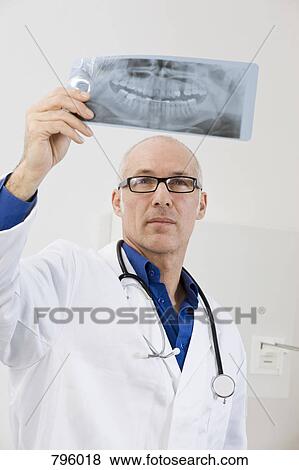 A dentist holding up an X-ray View Large Photo Image Stock Photo - A dentist holding up an X-ray. Fotosearch