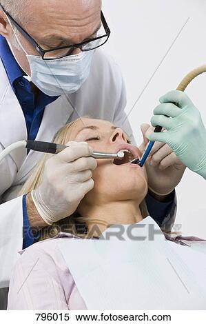 A dentist inspecting a woman's mouth View Large Photo Image Stock Photography - A dentist inspecting a woman's mouth. Fotosearch