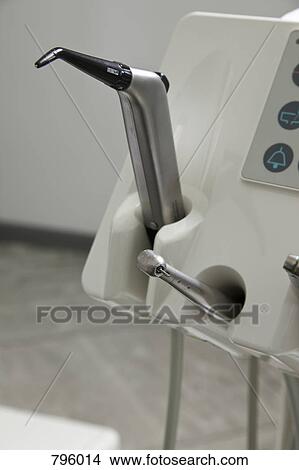 A drill and a suction device docked in a dental examination room View Large Photo Image Picture - A drill and a suction device docked in a dental examination room . Fotosearch