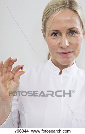 A medical worker holding a capsule View Large Photo Image Picture - A medical worker holding a capsule. Fotosearch