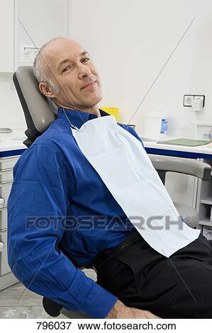 A patient sitting in a dentist's chair View Large Photo Image Stock Photo - A patient sitting in a dentist's chair. Fotosearch