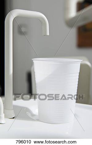 A plastic cup at the edge of a dental cuspidor View Large Photo Image Stock Image - A plastic cup at the edge of a dental cuspidor. Fotosearch
