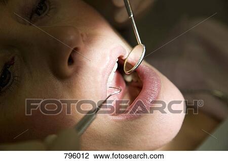 Close-up of a dentist inspecting a woman's mouth View Large Photo Image Stock Image - Close-up of a dentist inspecting a woman's mouth. Fotosearch