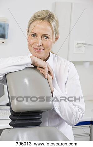 Portrait of a dental assistant sitting behind a dental chair View Large Photo Image Stock Image - Portrait of a dental assistant sitting behind a dental chair. Fotosearch