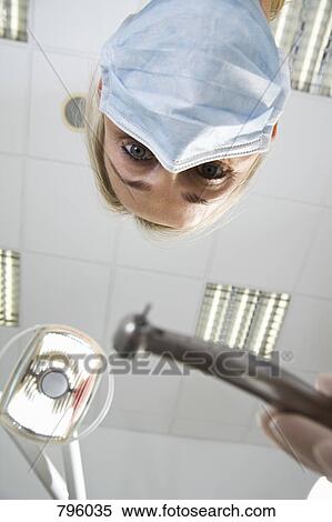 View from below of a dentist holding s drill View Large Photo Image Stock Photography - View from below of a dentist holding s drill. Fotosearch