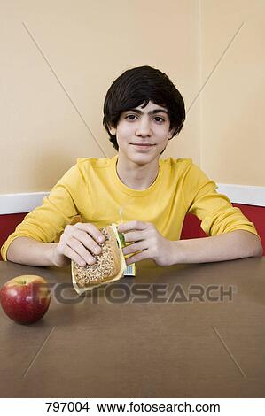 A schoolboy eating lunch View Large Photo Image Picture - A schoolboy eating lunch. Fotosearch
