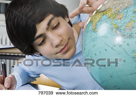 A schoolboy looking at a globe View Large Photo Image Stock Photo - A schoolboy looking at a globe. Fotosearch