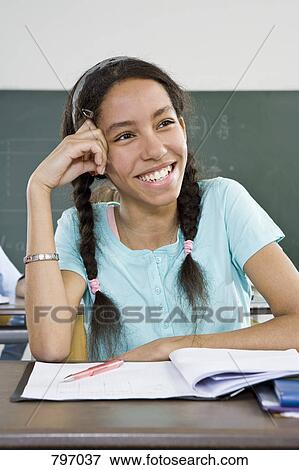 A schoolgirl sitting at a desk View Large Photo Image Stock Photo - A schoolgirl sitting at a desk. Fotosearch