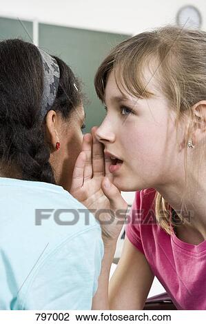A schoolgirl telling a secret to a friend View Large Photo Image Stock Image - A schoolgirl telling a secret to a friend. Fotosearch