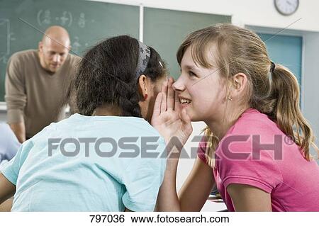 A schoolgirl telling a secret to a friend View Large Photo Image Stock Photograph - A schoolgirl telling a secret to a friend. Fotosearch