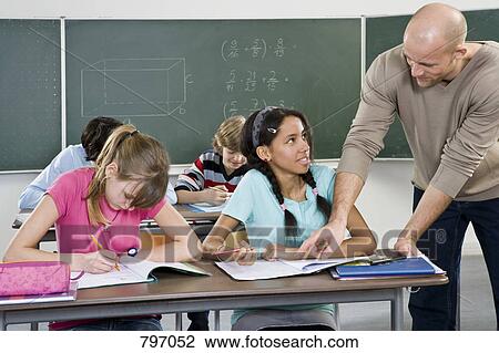A teacher working with students in a classroom View Large Photo Image Stock Image - A teacher working with students in a classroom. Fotosearch