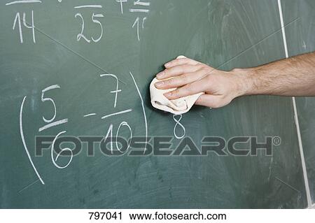 Stock Image - Detail of a man dusting a blackboard. Fotosearch