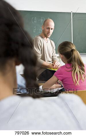 Over the shoulder view of a teacher teaching a class View Large Photo Image Stock Photograph - Over the shoulder view of a teacher teaching a class. Fotosearch
