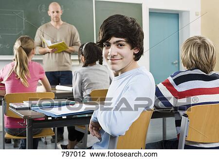Portrait of a boy sitting in a classroom View Large Photo Image Stock Image - Portrait of a boy sitting in a classroom. Fotosearch