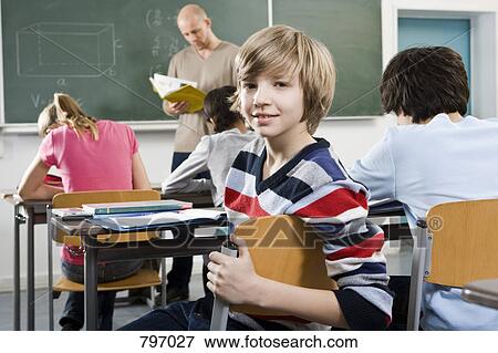 Portrait of a boy sitting in a classroom View Large Photo Image Stock Photo - Portrait of a boy sitting in a classroom. Fotosearch