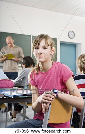 Portrait of a girl sitting in a classroom View Large Photo Image Stock Photograph - Portrait of a girl sitting in a classroom. Fotosearch