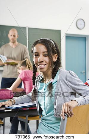 Portrait of a girl sitting in a classroom View Large Photo Image Stock Photography - Portrait of a girl sitting in a classroom. Fotosearch