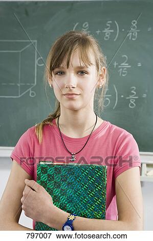 Portrait of a schoolgirl holding a book View Large Photo Image Stock Photo - Portrait of a schoolgirl holding a book. Fotosearch