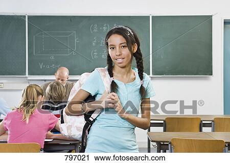 Portrait of a schoolgirl standing in a classroom View Large Photo Image Stock Image - Portrait of a schoolgirl standing in a classroom. Fotosearch