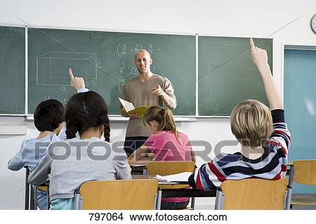 Rear view of a students raising their hands in a classroom View Large Photo Image Picture - Rear view of a students raising their hands in a classroom. Fotosearch