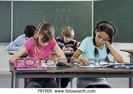 Stock Photography - School students working in a classroom. Fotosearch