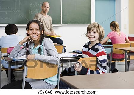 Two school children sitting in a classroom View Large Photo Image Stock Photo - Two school children sitting in a classroom. Fotosearch