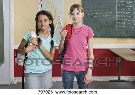 Two schoolgirls standing side by side View Large Photo Image Stock Photography - Two schoolgirls standing side by side. Fotosearch