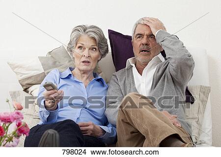 Picture - A couple watching something unbelievable on TV. Fotosearch