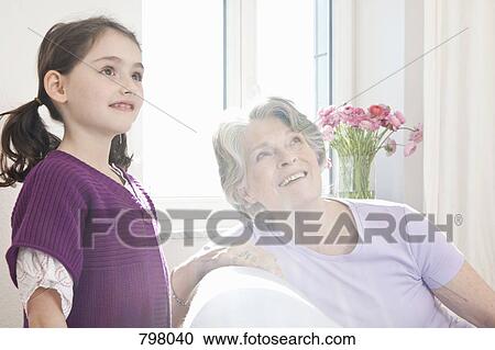 A girl and her granddaughter looking up curiously View Large Photo Image Stock Image - A girl and her granddaughter looking up curiously. Fotosearch