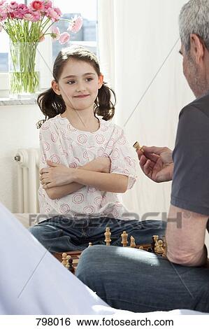 A girl and her grandfather playing chess View Large Photo Image Stock Photograph - A girl and her grandfather playing chess. Fotosearch