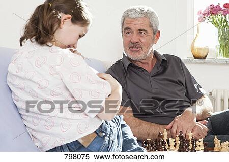A grandfather and his granddaughter playing chess View Large Photo Image Stock Photography - A grandfather and his granddaughter playing chess. Fotosearch