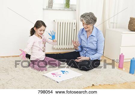 Picture - A grandmother and her granddaughter finger painting. Fotosearch